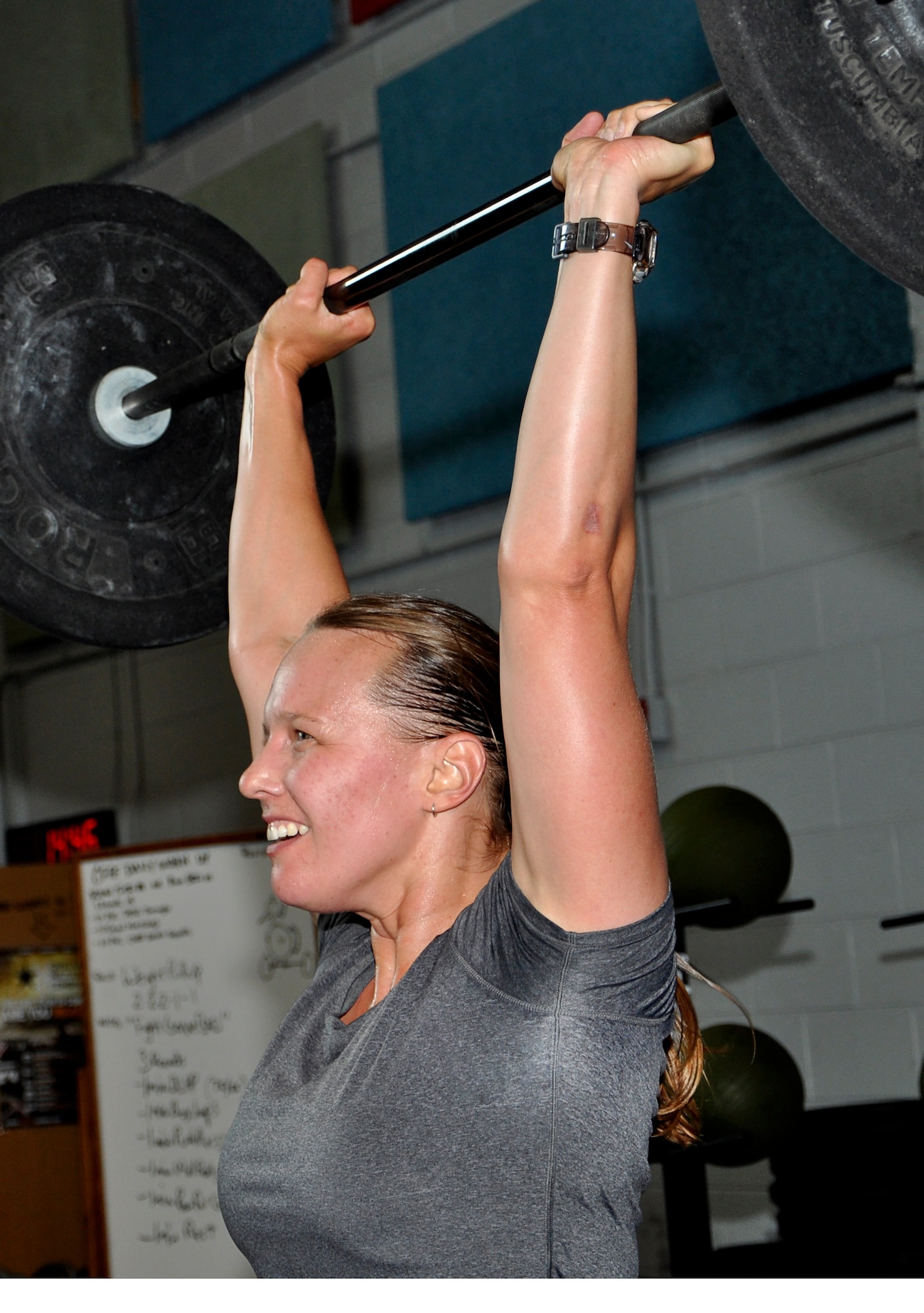 Jenee Sauer, a military spouse, performs a push press during a Functional Fitness Program “CrossFit” class at the Anderson Field House on Fort Eustis, Va., June 24, 2013. The Functional Fitness Program  workouts  are made up of three main disciplines: cardio, gymnastics and weightlifting, which are combined to create high-intensity workouts.  (U.S. Air Force photo by Tech. Sgt. April Wickes/Released)