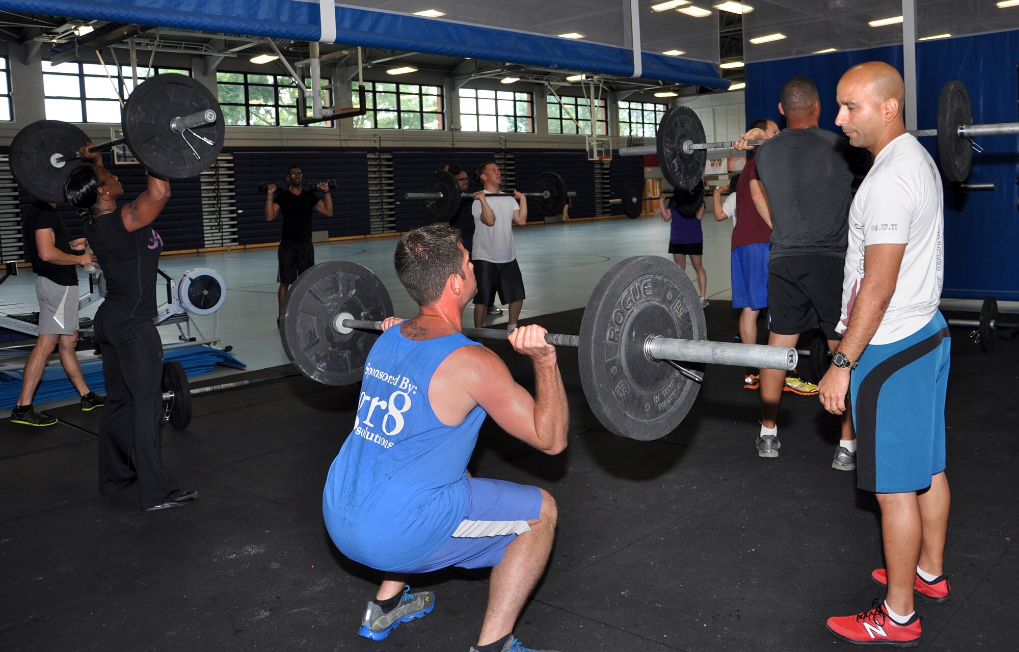 U.S. Navy Petty Officer 2nd Class Willie Fowler, Joint Task Force Civil Support damage controlman, performs a front squat, while his instructor, U.S. Marine Corps Gunnery Sgt. Juan C. Ospina, Joint Task Force Civil Support noncommissioned officer in charge of operations, watches to ensure correct form during Functional Fitness Program “CrossFit” class at the Anderson Field House on Fort Eustis, Va., June 19, 2013. Ospina said the correct form during weight lifting is important to prevent injuries. (U.S. Air Force photo by Tech. Sgt. April Wickes/Released)