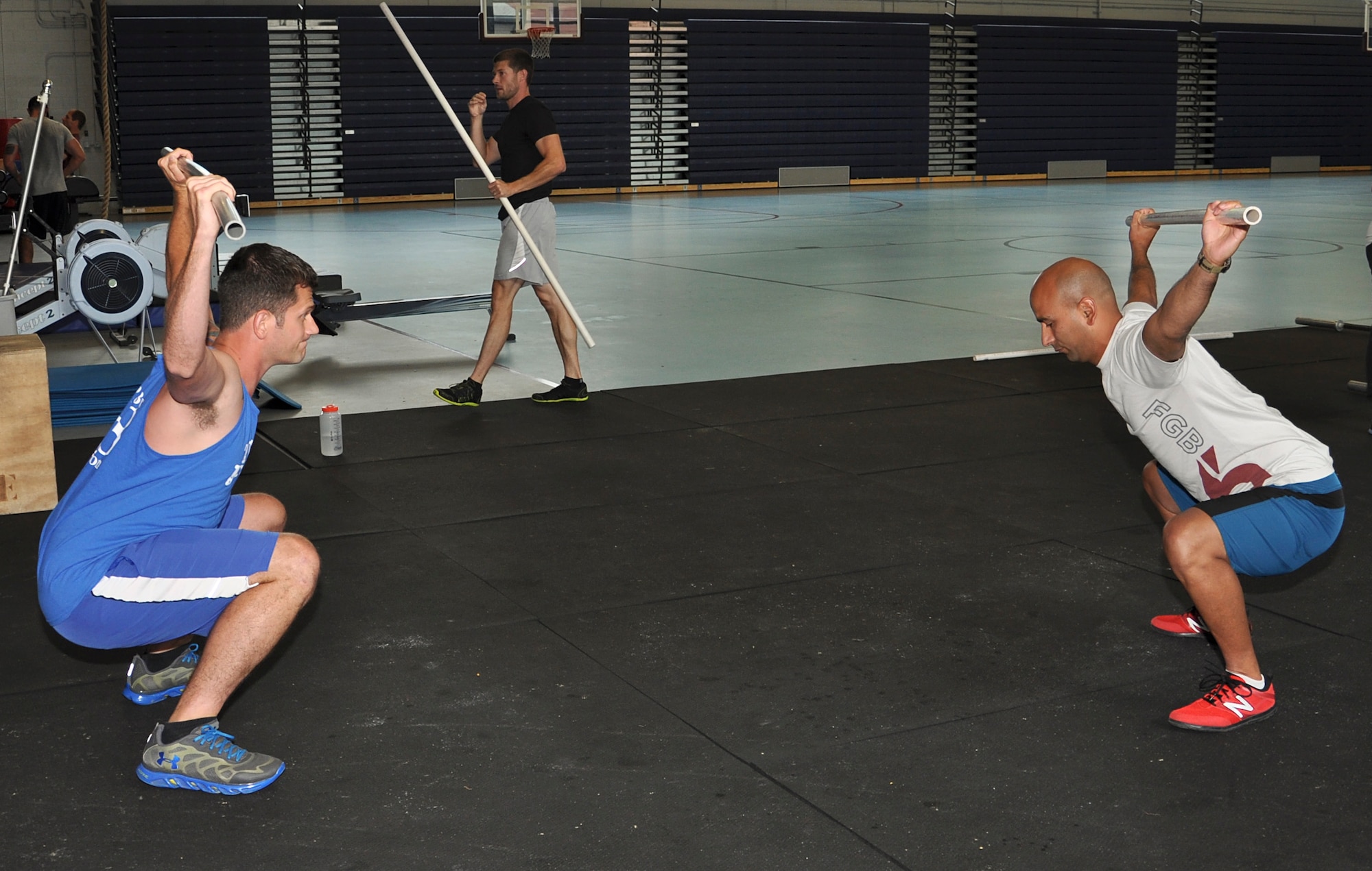 (From left)U.S. Navy Petty Officer 2nd Class Willie Fowler, Joint Task Force Civil Support damage controlman, practices warm-up techniques with U.S. Marine Corps Gunnery Sgt. Juan C. Ospina, Joint Task Force Civil Support noncommissioned officer in charge of operations and Functional Fitness Program instructor, at the Anderson Field House on Fort Eustis, Va., June 19, 2013. The Functional Fitness Program is a “CrossFit” workout that teaches students functional movements. (U.S. Air Force photo by Tech. Sgt. April Wickes/Released)