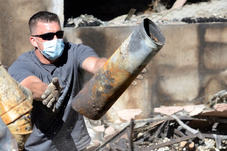 Staff Sgt. Benjamin Wierzba, 4th Space Operations Squadron, sorts scrap metal from a home destroyed in the Black Forest fire. Several members of 4 SOPS came together June 26 to help one of their own sort through the ashes of their home. Volunteers from the squadron also plan to help with two additional homes lost to 4 SOPS members. (U.S. Air Force photo/Staff Sgt. Robert Cloys)