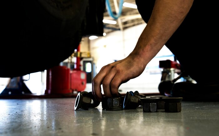 Senior Airman Matthew Trevino, 628th Logistics Readiness Squadron vehicle maintenance technician, places lug nuts on the bay floor after removing a tire to perform brake maintenance June 25, 2013, at Joint Base Charleston – Air Base, S.C. Vehicle maintenance technicians maintain JB Charleston's entire vehicle fleet, keeping cars, trucks and buses operating smoothly. (U.S. Air Force photo/ Senior Airman George Goslin)