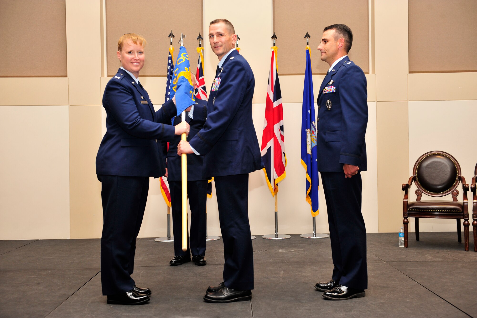 Col. DeAnna Burt, left, 460th Operations Group commander, presents the 2nd Space Warning Squadron guidon to Lt. Col. Francois Roy, middle, 2nd SWS commander, as Lt. Col. John Henley, former 2nd SWS commander stands by June 19, 2013, at the Leadership Development Center on Buckley Air Force Base, Colo. For Roy, this will be his first command of a squadron. (U.S. Air Force photo by Airman 1st Class Darryl Bolden Jr./Released)