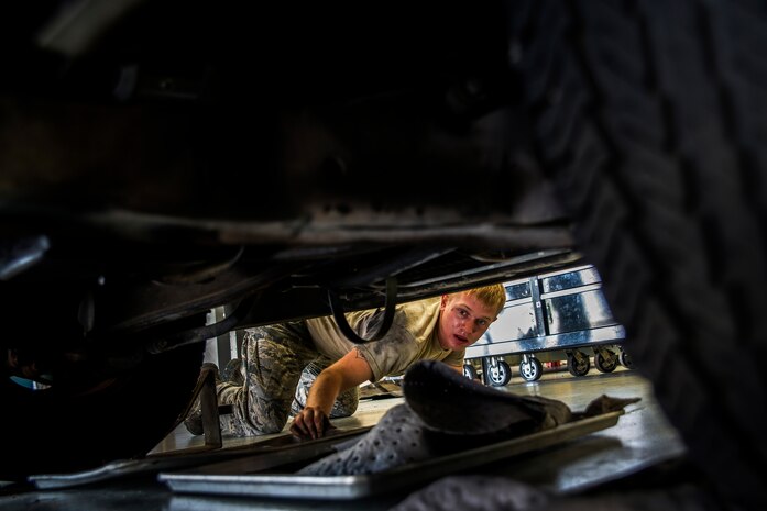 Senior Airman Matthew Fincher, 628th Logistics Readiness Squadron vehicle maintenance technician, positions  an oil pan under a truck while conducting maintenance June 25, 2013, at Joint Base Charleston – Air Base, S.C. Vehicle maintenance technicians maintain JB Charleston's entire vehicle fleet, keeping cars, trucks and buses operating smoothly. (U.S. Air Force photo/ Senior Airman George Goslin)