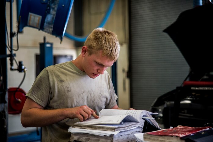 Senior Airman Matthew Fincher, 628th Logistics Readiness Squadron vehicle maintenance technician, refers to  a manual before performing maintenance on a truck June 25, 2013, at Joint Base Charleston – Air Base, S.C. Vehicle maintenance technicians maintain JB Charleston's entire vehicle fleet, keeping cars, trucks and buses operating smoothly. (U.S. Air Force photo/ Senior Airman George Goslin)