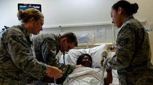 The Intensive Care Unit staff checks the vital signs of U.S. Air Force Staff Sgt. Portia Les’Pere, 633rd Inpatient Operations Squadron aerospace medical technician, while simulating emergency procedures at the U.S. Air Force Hospital Langley Intensive Care Unit at Langley Air Force Base, Va., June 26, 2013. A recent hospital-wide expansion offers medical providers the opportunity to work closely with professionals in other subspecialties to ensure the patients’ needs are met when they need it most. (U.S. Air Force photo by Airman 1st Class R. Alex Durbin/Released)