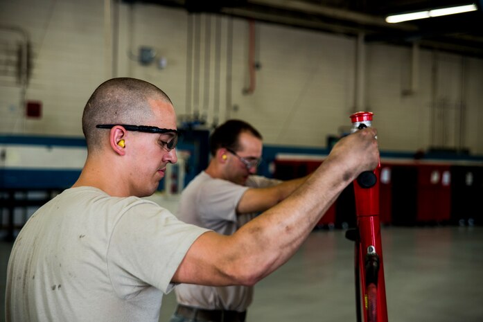 Airman 1st Class Joshua Wachtel and Senior Airman Matthew Trevino, 628th Logistics Readiness Squadron vehicle maintenance technicians, use hydraulic floor jacks to lift a vehicle for brake maintenance, June 25, 2013, at Joint Base Charleston – Air Base, S.C. Vehicle maintenance technicians maintain JB Charleston's entire vehicle fleet, keeping cars, trucks and buses operating smoothly. (U.S. Air Force photo/ Senior Airman George Goslin)