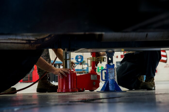 Airman 1st Class Joshua Wachtel and Senior Airman Matthew Trevino, 628th Logistics Readiness Squadron vehicle maintenance technicians, use a hydraulic floor jack to lift a vehicle for brake maintenance ,June 25, 2013, at Joint Base Charleston – Air Base, S.C. Vehicle maintenance technicians maintain JB Charleston's entire vehicle fleet, keeping cars, trucks and buses operating smoothly. (U.S. Air Force photo/ Senior Airman George Goslin)