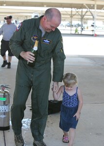 Col. David Drichta, 12th Operations Group deputy commander, and his daughter Allison walk to the squadron after his first flight back after his battle with cancer at Joint Base San Antonio-Randolph, Texas June 19, 2013.  Drichta was diagnosed with Stage IV cancer in February 2012 and, after more than a year in recovery, was medically cleared to return to flight status.  The flight marked his return to flight status as well as his 3,000th flight hour in Air Force aircraft. (Courtesy photo by Stacy Nyikos)
