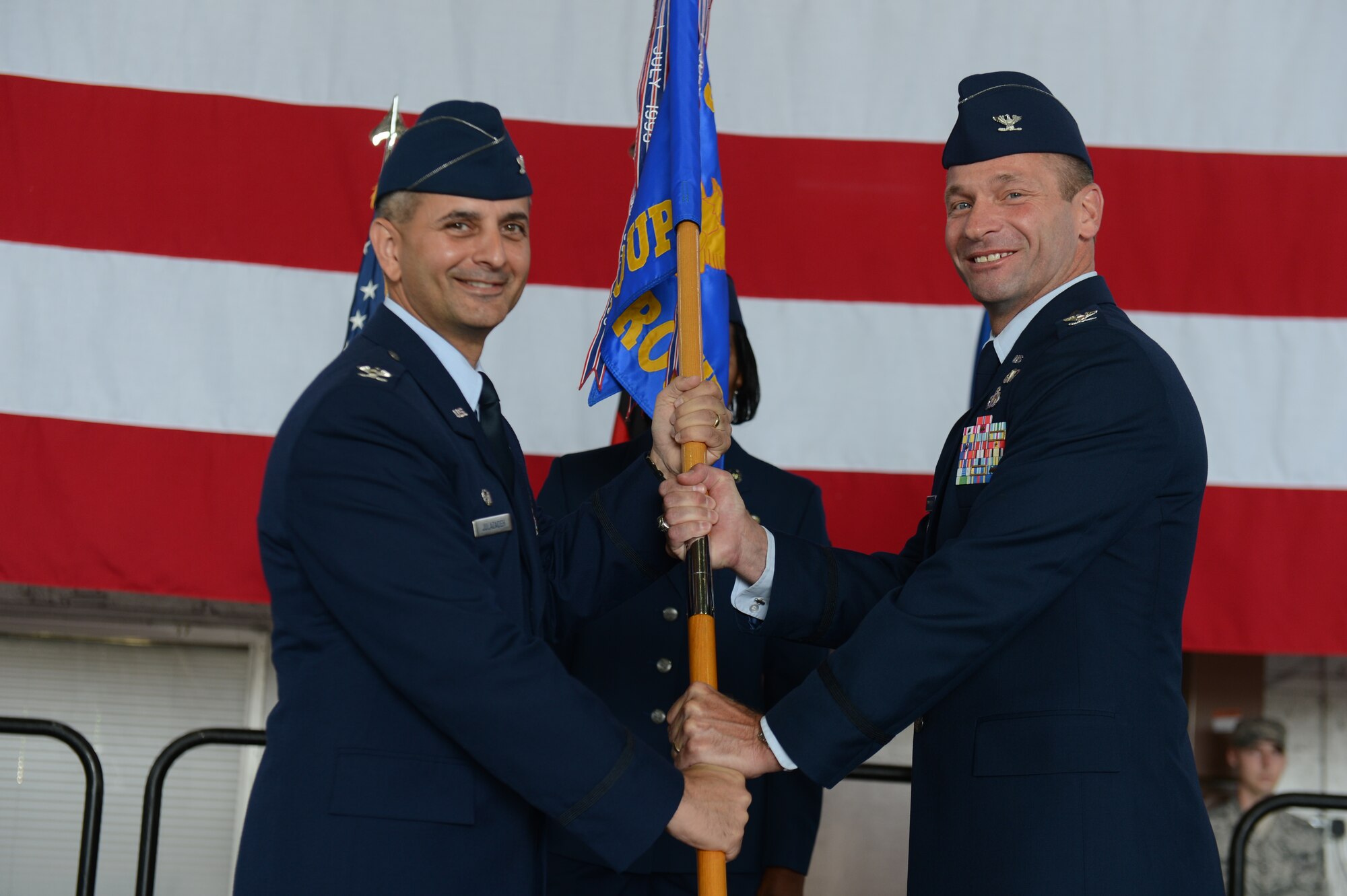 U.S. Air Force Col. Nathan Rump, 52nd Mission Support Group commander, right, receives the 52nd MSG guidon from U.S. Air Force Col. David Julazadeh, 52nd Fighter Wing commander, during a change of command ceremony June 28, 2013. Rump accepted command from U.S. Air Force Col. Scott Calisti, the outgoing 52nd MSG commander. A change of command is a military tradition that represents a formal transfer of authority and responsibility for a unit from one commanding officer to another. (U.S. Air Force photo by Airman 1st Class Gustavo Castillo/Released)