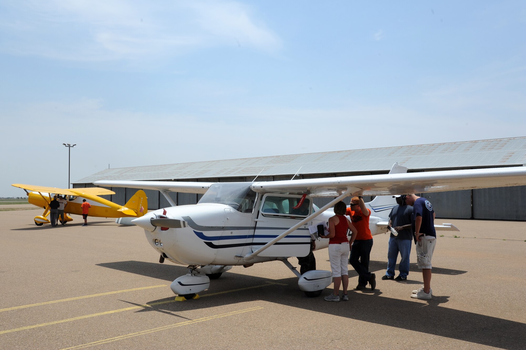 Spectators view an aircraft flown by the Civil Air Patrol (foreground) at Clovis Municipal Airport in Clovis, N.M., during an open house, June 22, 2013.  CAP is an organization comprised of volunteers that serves as an auxiliary to the U.S. Air Force.  (U.S. Air Force photo/Senior Airman Jette Carr)