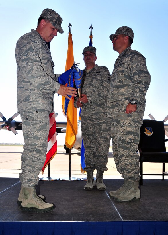 U.S. Air Force Col. Buck Elton, 27th Special Operations Wing commander, unfurls the 27th Special Operations Air Operations Squadron guidon for the first time, during a squadron activation ceremony, at Cannon Air Force Base, N.M., June 27, 2013. Taking command of the newly minted squadron is Lt. Col. Edward Espinoza, who is charged with the responsibility of planning, directing, coordinating and controlling aircraft, personnel and resources at the 27 SOW as well as shouldering responsibility for the wing’s global command and control mission. (U.S. Air Force photo/Senior Airman Whitney Tucker)