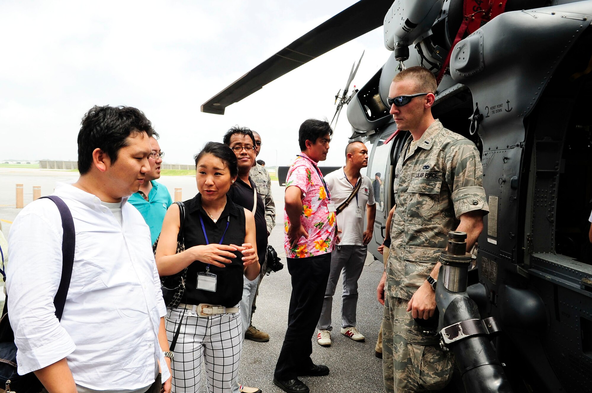 Junior Chamber International Japan members ask questions about the HH-60 Pavehawk helicopter to U.S. Air Force 1st Lt. Nicholas Mangus, 718th Aircraft Maintenance Squadron 33rd Helicopter Maintenance Unit officer in charge, during their study tour visit to Kadena Air Base, Japan, June 28, 2013. The Junior Chamber members got a chance to receive briefings about the capabilities of an F-15 Eagle aircraft, HH-60 Pavehawk and KC-135 Stratotanker aircraft during their visit. (U.S. Air Force photo by Staff Sgt. Darnell T. Cannady/Released)