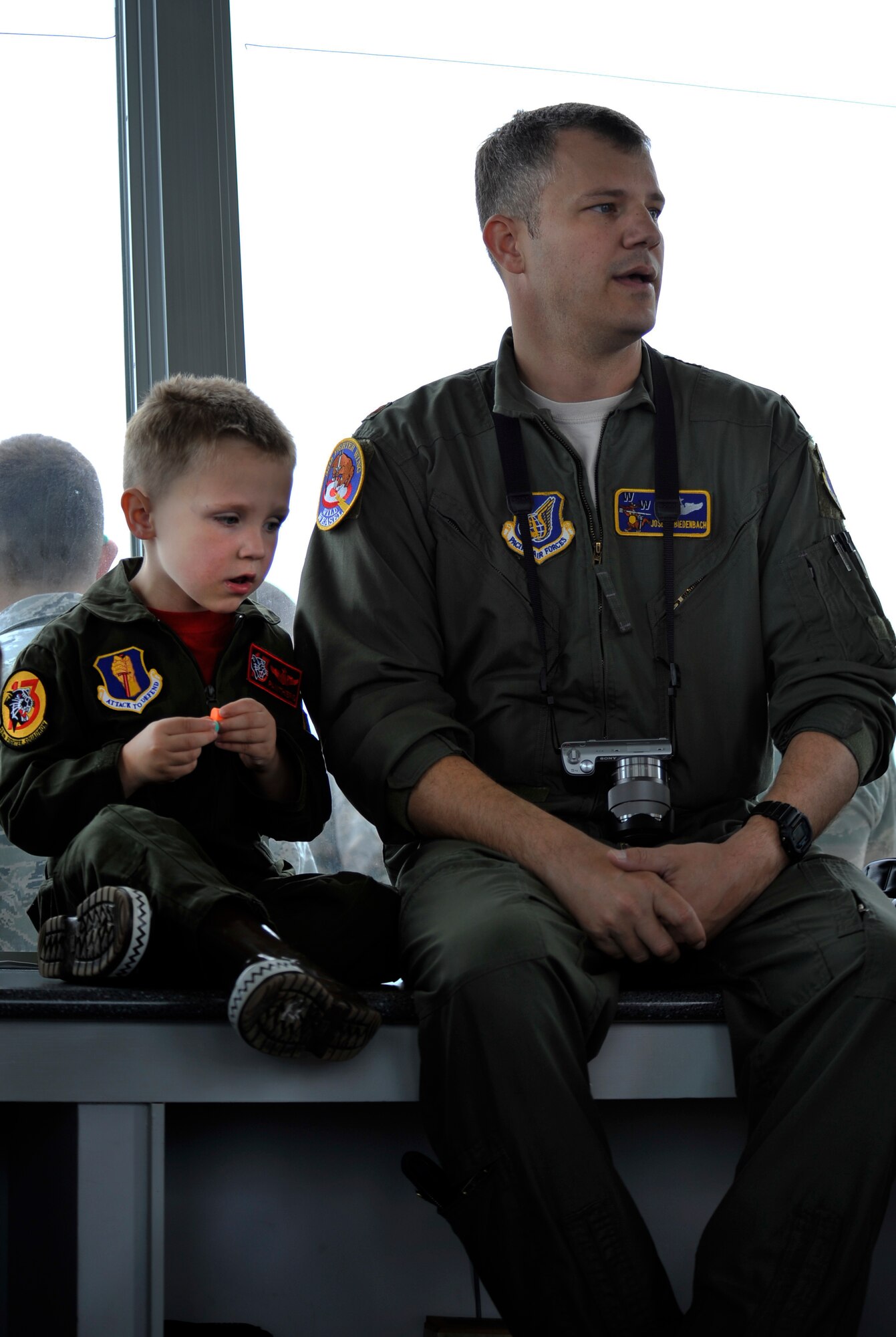 U.S. Air Force Maj. Joseph Biedenbach, 35th Fighter Wing Inspector General, and his son Tyler sit in the control tower at Draughon Range, Japan, June 28, 2013. Biedenbach, along with the 35th Operations Group, spent the day on the range for a group family day where they got to see F-16 Fighting Falcons in action. (U.S. Air Force photo by Airman 1st Class Zachary Kee)