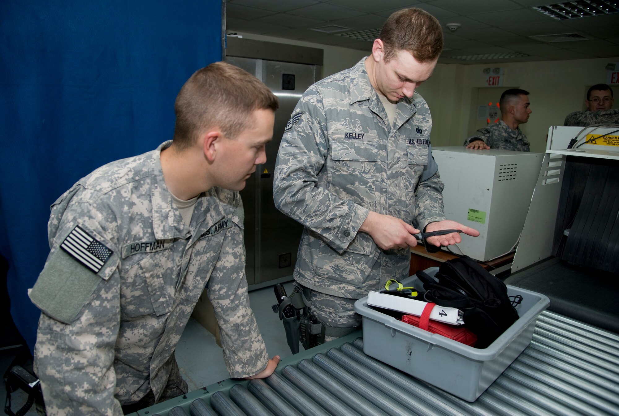 U.S. Army Cpl. Jeff Hoffman, 391st Military Police Battalion, Detachment  5, left, and U.S. Air Force Staff Sgt. Michael Kelley, 376th Expeditionary Security Forces Squadron, right, inspect belongings before they enter Transit Center at Manas, Kyrgyzstan, June 27, 2013. Air Force and Army service members joined forces to guard the Transit Center Access Point because of a manning shortfall. (U.S. Air Force photo/Staff Sgt. Krystie Martinez)