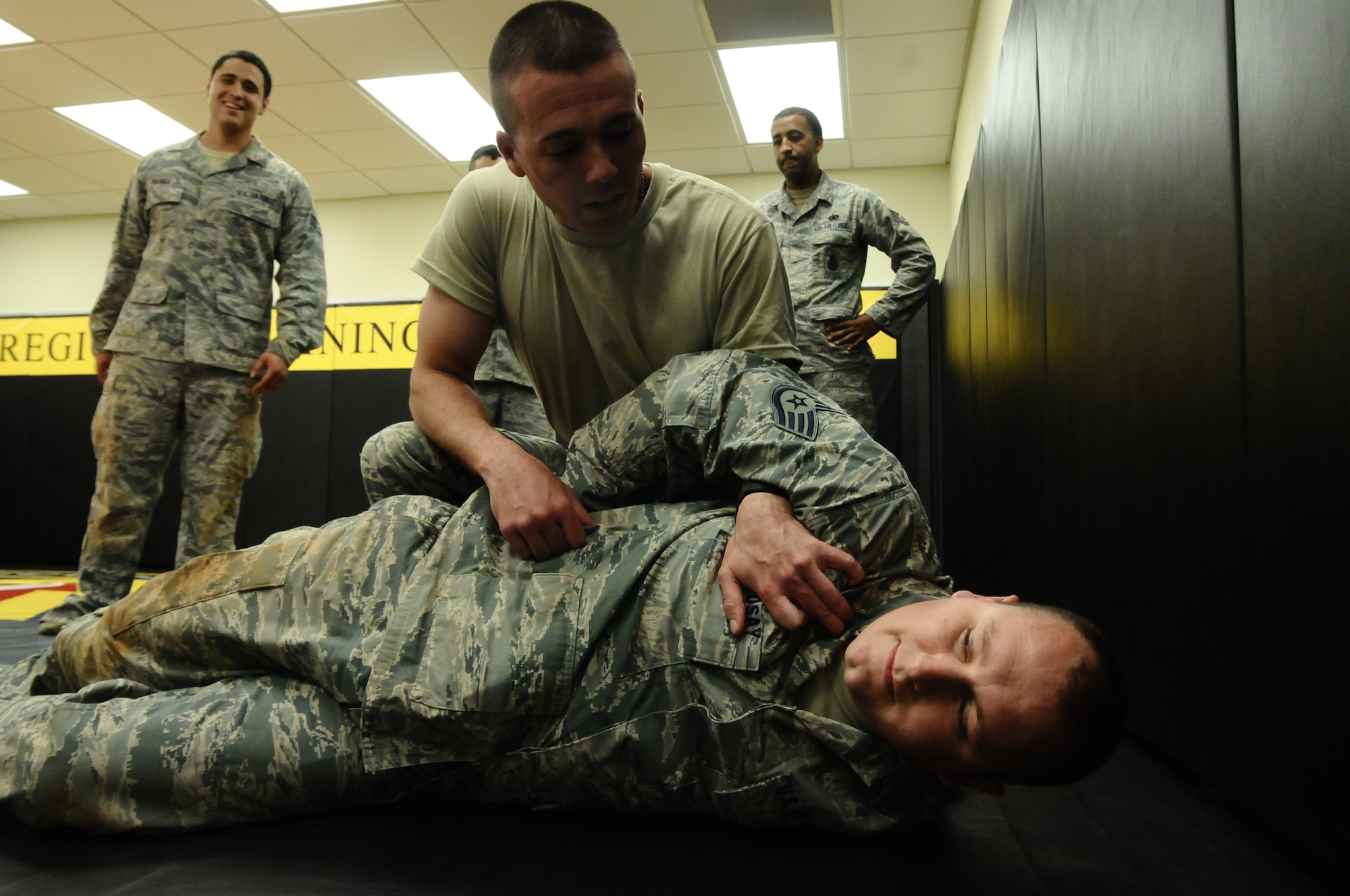 Staff Sgt. Clint Seal, 736th Security Forces Squadron Pacific Regional Training Center Commando Warrior instructor, and Staff Sgt. Jason Brown, 736th SFS PRTC Commando Warrior instructor, demonstrate the proper way to search and handcuff a suspect during a scenario at the PRTC on Northwest Field, Guam, June 26, 2013. The training was part of a new sustainment training program that will become part of a monthly regimen designed to keep Airmen current on skills such as rules of engagement, use of force, integrated defense and rifle-fighting techniques. (U.S. Air Force photo by Airman 1st Class Mariah Haddenham/Released)