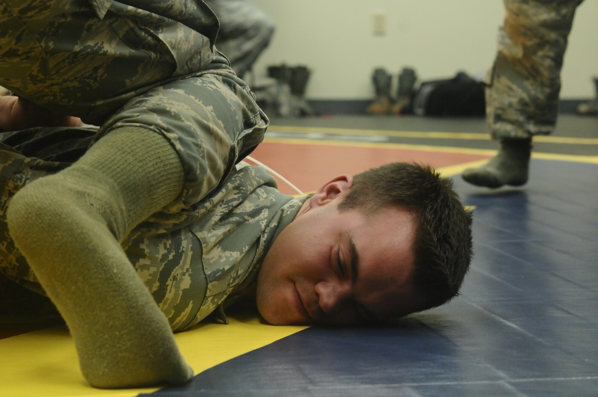Airman 1st Class Kyle Wilson, 36th Contingency Response Group knowledge operations apprentice, is handcuffed as part of a combatives training scenario at the Pacific Regional Training Center on Northwest Field, Guam, June 26, 2013. The training was part of a new sustainment training program that will become part of a monthly regimen designed to keep Airmen current on skills such as rules of engagement, use of force, integrated defense and rifle-fighting techniques. (U.S. Air Force photo by Airman 1st Class Mariah Haddenham/Released)