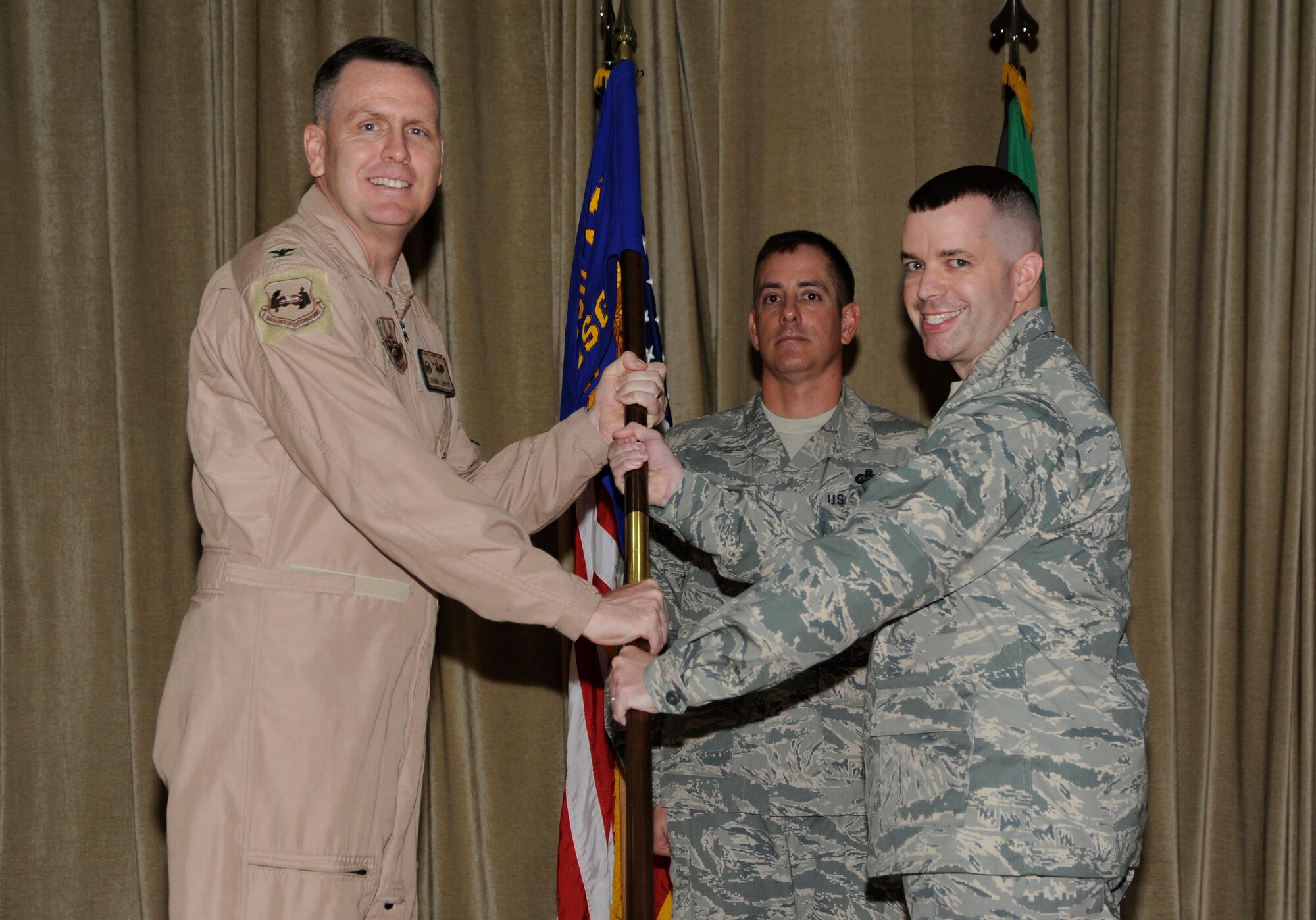 Colonel David S. Farrow, 386th Air Expeditionary Wing commander, left, passes the 386th Expeditionary Mission Support Group guidon to Col. David Sanford during a change of command ceremony at an undisclosed location in Southwest Asia June 30, 2013. Sanford assumed command of the 386th EMSG from Col. Joseph Martin.  (U.S. Air Force photo by Master Sgt. Christopher A. Campbell)