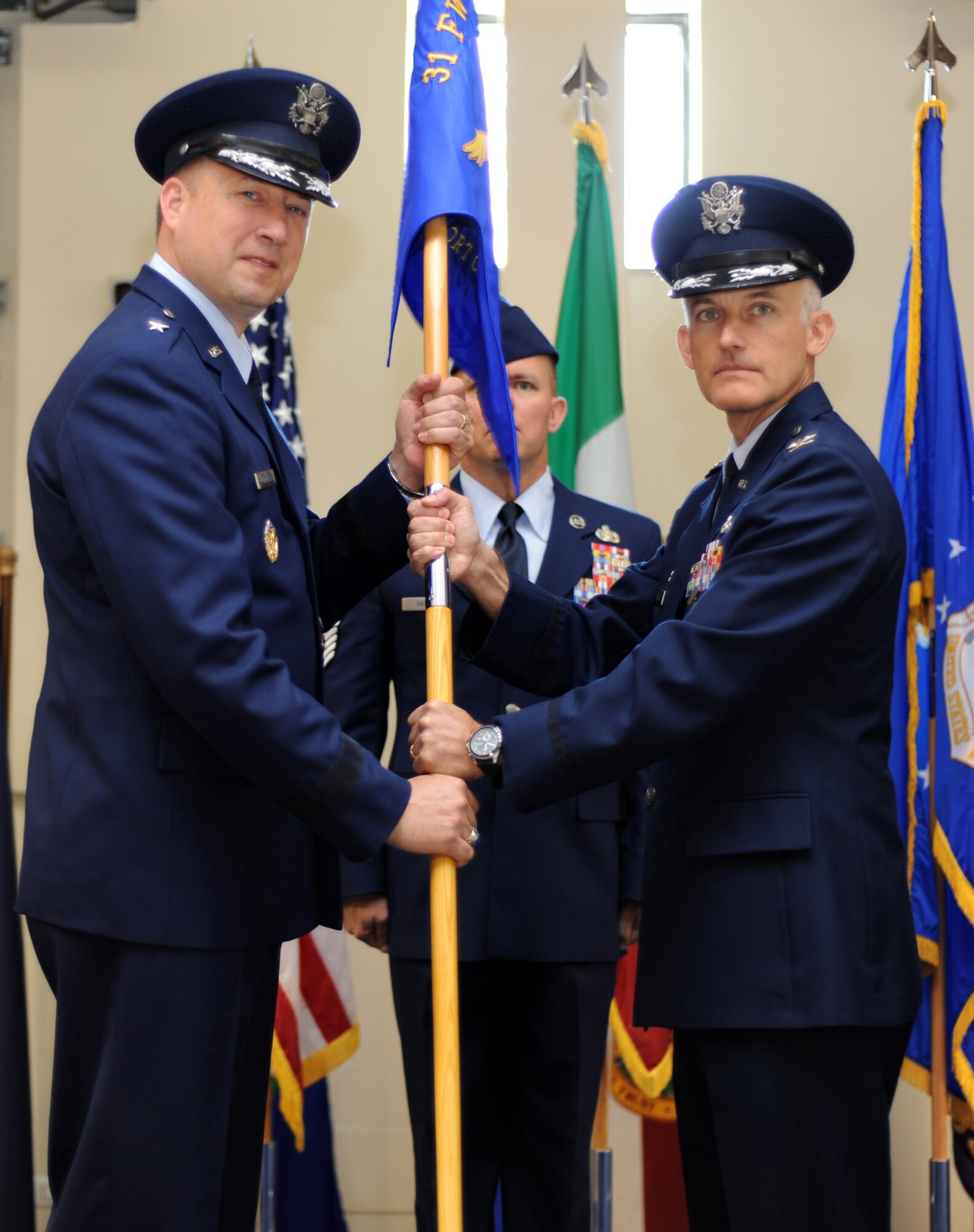 Col. Brian Pukall relinquishes the 31st Mission Support Group guidon to Brig. Gen. Jon A. Norman during a change of command ceremony June 28, 2013, at Aviano Air Base, Italy. Nearly 500 people attended the ceremony and the audience included Airmen, Soldiers, Italian air force members and local community leaders. (U.S. Air Force photo/Staff Sgt. Justin Weaver)