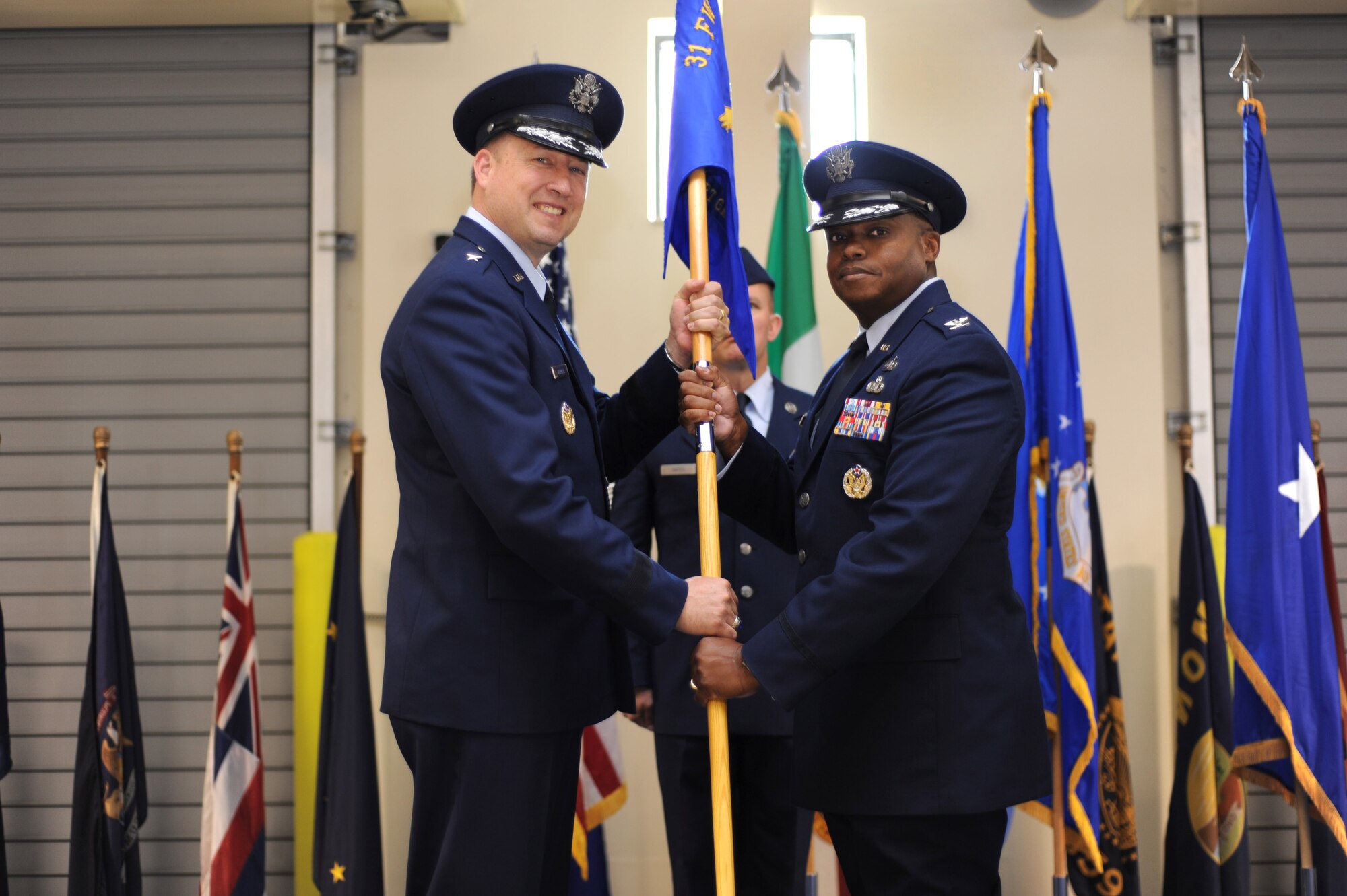 Brig. Gen. Jon A. Norman, 31st Fighter Wing commander, passes the 31st Mission Support Group guidon to Col. Harry Lane during a change of command ceremony June 28, 2013, at Aviano Air Base, Italy. As commander, Lane oversees six squadrons and provides administrative, security, communications, services, logistics readiness, infrastructure support and development for all the 31st FW personnel. (U.S. Air Force photo/Staff Sgt. Justin Weaver)