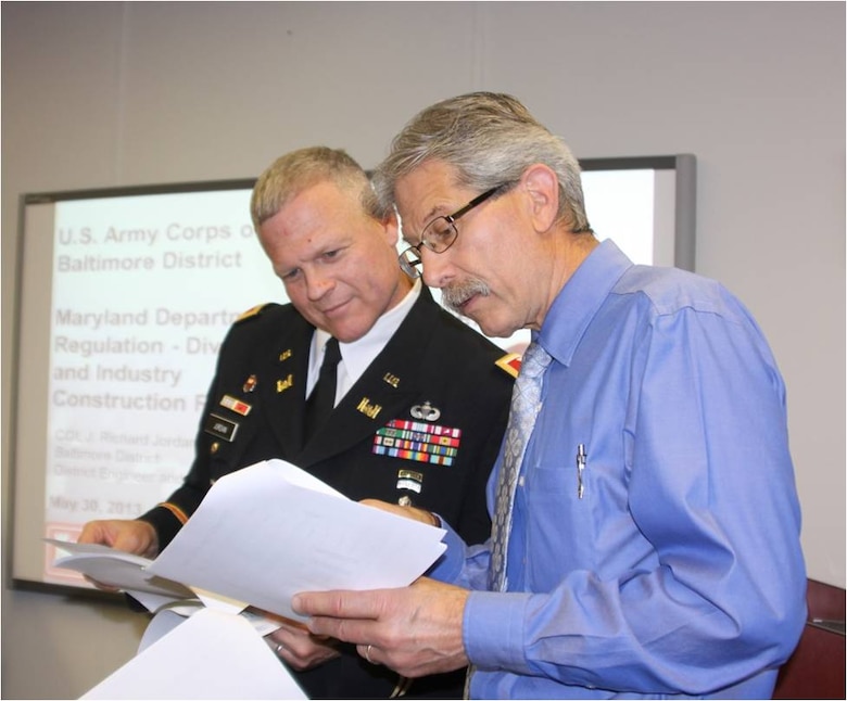 Col. Trey Jordan, Baltimore District commander, reviews data with employee Frank Benvenga prior to the start of the Construction Roundtable.