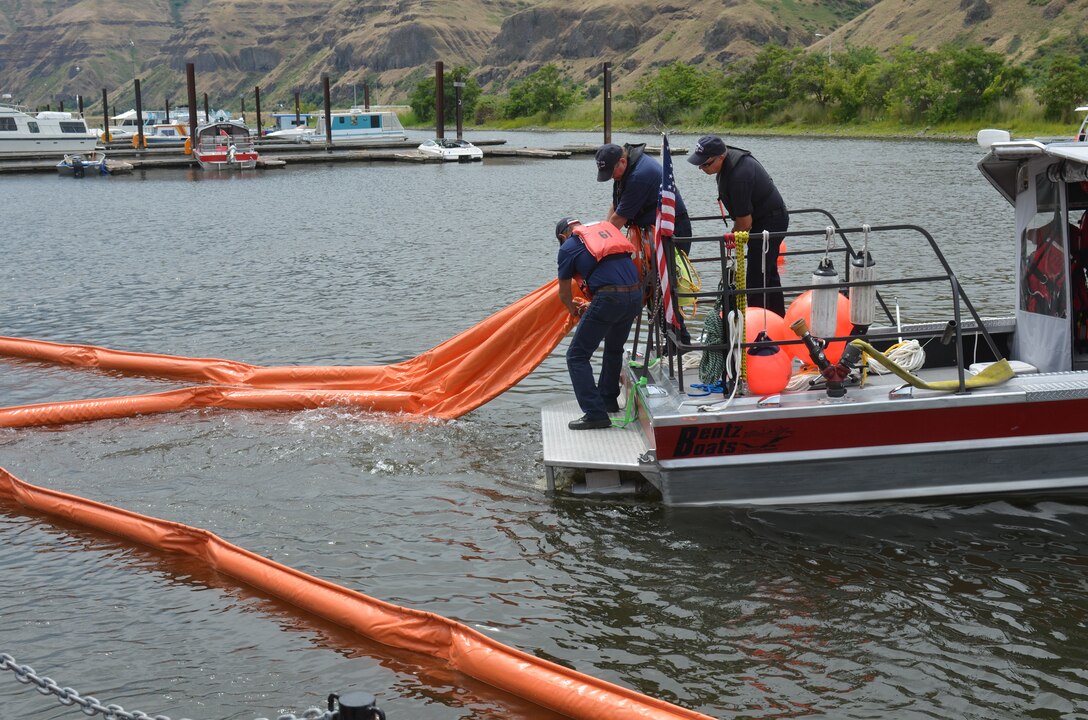 Asotin County Fire District boat and crew deploy an oil containment boom.