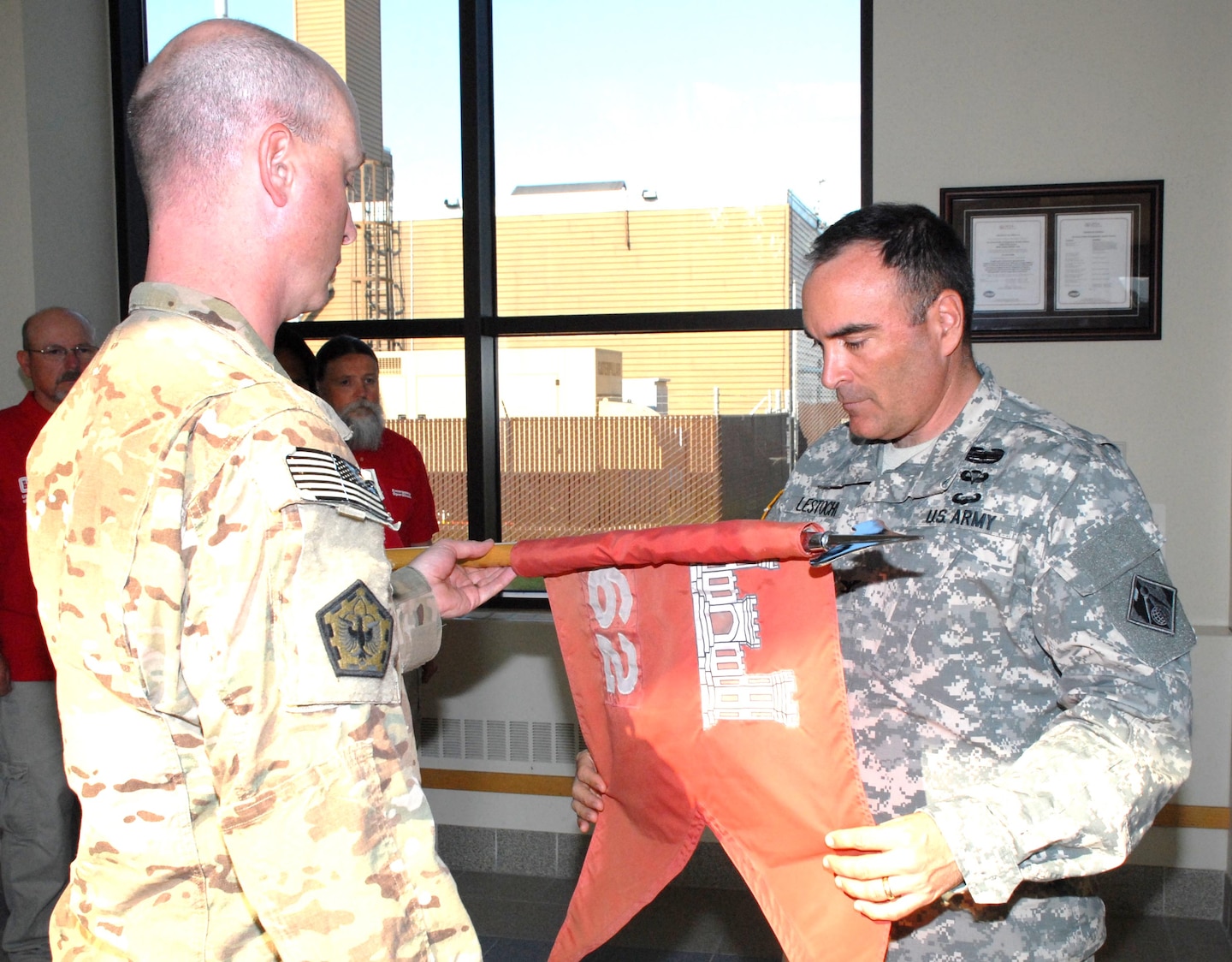 Col. Christopher Lestochi, district commander, uncases the colors of the 62nd Engineering Detachment with Capt. Corey Warren, detachment commander, during a ceremony June 26 at the district headquarters building. The team was deployed September 2012 through June 2013 in support of Operation Enduring Freedom at Shindand Air Base, Afghanistan.