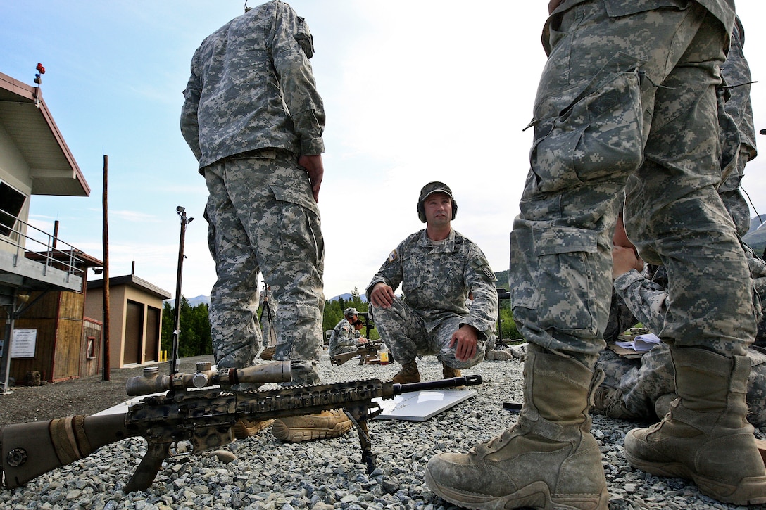 Army Sgt. 1st Class Adam James, center, instructs students on the ...
