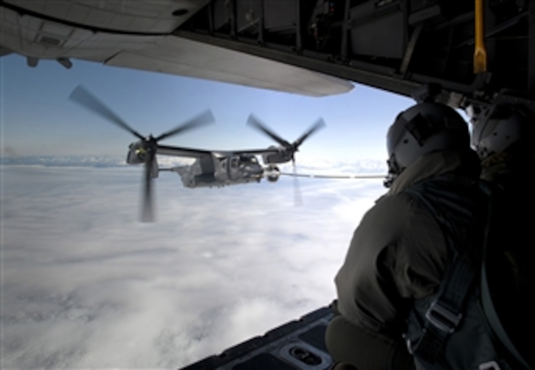 Crewmembers of an MC-130H Combat Talon II watch as they conduct an inflight refueling with a CV-22B Osprey off the coast of Greenland on June 21, 2013.  The Osprey, assigned to the 7th Special Operations Squadron at Royal Air Force Mildenhall, England, is the first of 10 slated to arrive as part of the 352nd Special Operations Group expansion.  The MC-130 is also assigned to the 7th SOS.  