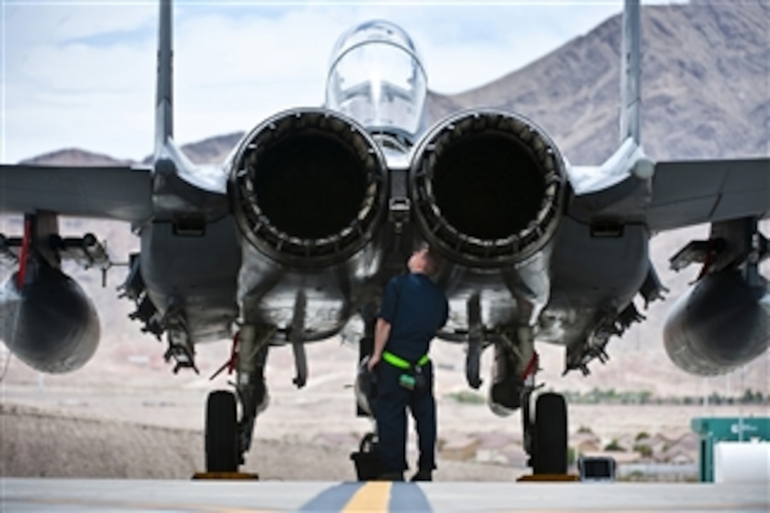 U.S. Air Force Senior Airman Nicholas Smyth inspects an F-15E Strike Eagle at Nellis Air Force Base, Nev., on June 24, 2013.  Smyth is a crew chief assigned to the 4th Aircraft Maintenance Squadron at Seymour Johnson Air Force Base, N.C.  