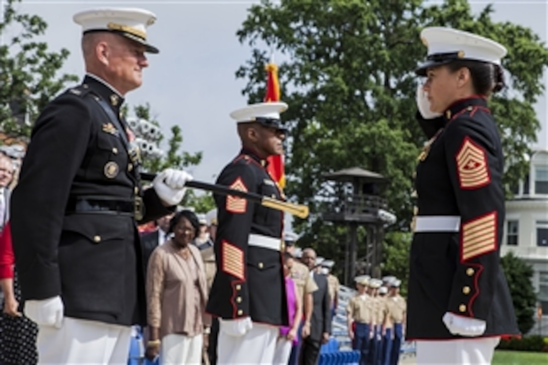 U.S. Marine Corps Sgt. Maj. Angela M. Maness, right, salutes Col. Christian Cabaniss, left, as she assumes her duties as Marine Barracks Washington, D.C., sergeant major during a ceremony in Washington, D.C., on June 27, 2013.  Maness relieved Sgt. Maj. Eric J. Stockton, center, who retired during the ceremony after more than 30 years of service.  