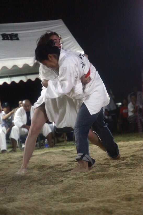 Pfc. Danielle A. Auld, left, takes on her challenger at the Henoko Okinawa-Style Sumo Tournament June 22 at the Mae-No-Hama Field. In the tournament’s challenge matches, audience members challenge each other to a single bout for fun. Auld won both her matches against her challengers. Auld is an ammunition technician with 3rd Supply Battalion, Combat Logistics Regiment 35, 3rd Marine Logistics Group, III Marine Expeditionary Force. 