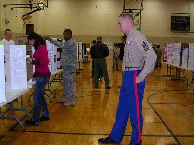 Volunteers from the North American Aerospace Defense Command and the U.S. Northern Command judge entries at the 2nd Annual Mitchell High School Science Fair Competition. NORAD and USNORTHCOM participates with Mitchell High School in a partnership educational program to aid in the overall educational experience for the students of District 11.