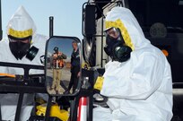 Sgt. Anthony Rigano (left) and Sgt. Ryan Campbell (right), both survey team members, 92nd Civil Support Team, Nevada National Guard, prepare to enter the simulated contaminated zone while Phillip Barnes (orange vest), operations analyst Team B, West Division, Civil Support Training Activity, U.S. Army North, evaluates the team during the 92nd CST’s evaluation exercise Feb. 10 at the National Guard Readiness Center in Las Vegas.
