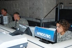 Search and rescue coordinators Major Bill Kennedy and Staff Sergeant Diane Brown monitor ongoing search and rescue operations.  The Air
Force Rescue Coordination Center serves as the single agency responsible for coordinating life saving federal search and rescue services. 