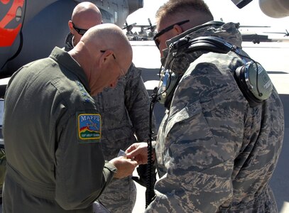 Air Force Gen. Gene Renuart, North American Aerospace Defense Command and U.S. Northern Command commander, accepts a challenge coin from Tech. Sgt. Manuel Ortega, 302nd Aircraft Maintenance Squadron, before his final flight at Peterson Air Force Base May 5. 