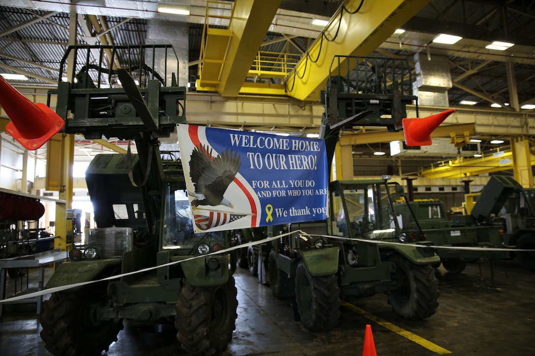 Two vehicles hold a welcome home banner during a homecoming event at Camp Lejeune, N.C., for Combat Logistics Regiment 2, 2nd Marine Logistics Group, July 1, 2013. Service members returned from a six month deployment to Afghanistan in support of Operation Enduring Freedom.  (U.S. Marine Corps photo by Lance Cpl. Shawn Valosin)