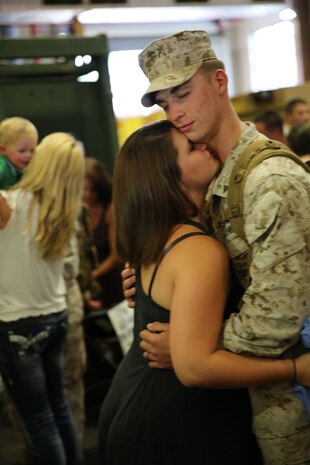 A Marine with Combat Logistics Regiment 2, 2nd Marine Logistics Group hugs his pregnant wife during a homecoming event held aboard Camp Lejeune, N.C., July 1, 2013.  Marines and sailors returned from a six month deployment to Afghanistan in support of Operation Enduring Freedom. (U.S. Marine Corps photo by Lance Cpl. Shawn Valosin)