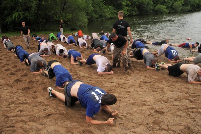 Marines with Recruiting Station Twin Cities motivate members of the Woodbury High School Football Team during a workout challenge June 21. Players went through several exercise stations that focused on different muscle groups. For additional imagery from the event visit www.facebook.com/rstwincities.