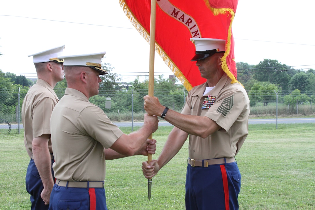 Sgt. Maj. William E. Sweeney, Recruiting Station Frederick’s sergeant major, hands RS Frederick’s colors to Major James Birchfield, III during the change of command ceremony where Birchfield relinquished command to Maj. Paul B. Bock, June 28 in Frederick, Md.