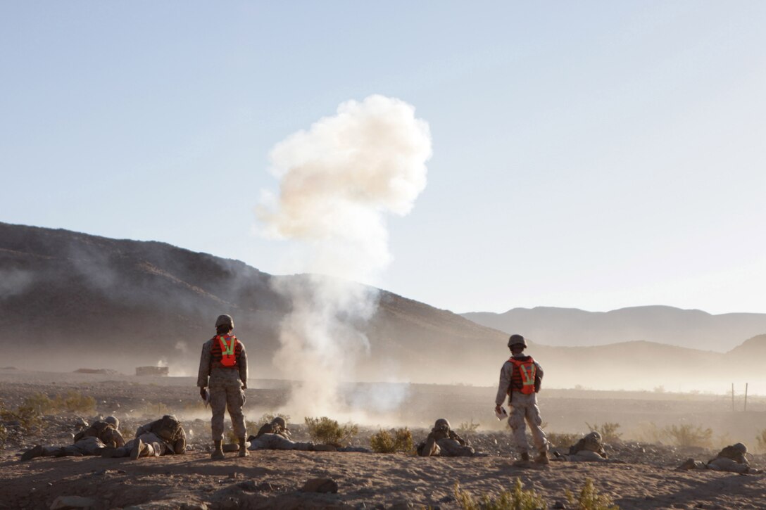 TWENTYNINE PALMS, Calif. – Marines with Company B, 1st Battalion, 24th Marine Regiment, fire down range while notional enemy mortar fire explodes nearby during a training exercise at Marine Corps Air-Ground Combat Center here, June 18. Range 410A allows Marines the opportunity to work on small-unit leadership by completing a series of obstacles that involve a platoon-sized element. Range 410A is part of Integrated Training Exercise 4-13, a cornerstone of the Marine Air-Ground Task Force Training Program. ITX 4-13, utilizing assets from ground, air and logistic combat elements is a live, virtual, constructive battalion exercise. (U.S. Marine Corps photo by Cpl. John M. McCall) 