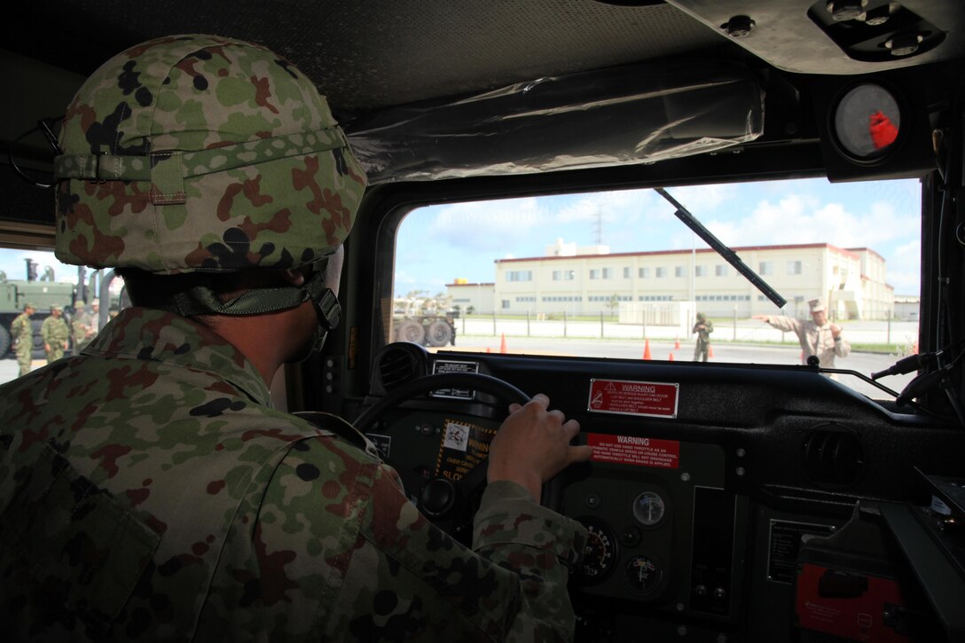 Sgt. Tanda Daisuke maneuvers a Humvee through a driving course June 25 on Camp Foster during a two-day bilateral training event.  Marines trained Japan Ground Self-Defense Force members on the capabilities of Marine Corps vehicles and basic logistics tactics and techniques. Daisuke is an infantryman with the 12th Infantry Regiment, Headquarters Company, JGSDF. The Marines are with Combat Logistics Battalion 4, Combat Logistics Regiment 3, 3rd Marine Logistics Group, III Marine Expeditionary Force. (U.S. Marine Corps photo by Lance Cpl. Anne K. Henry/Released)