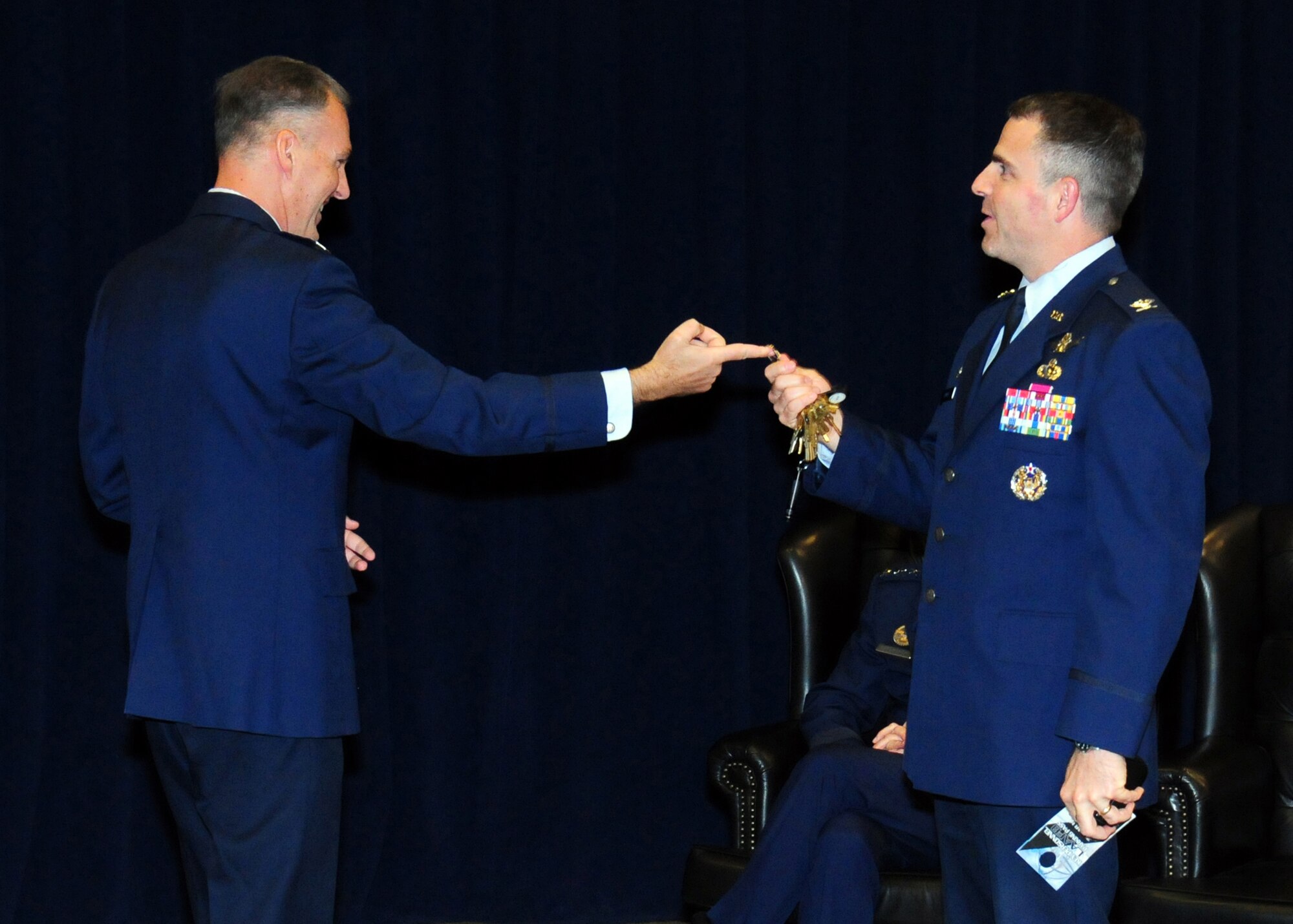 Colonel Bernard Gruber, outgoing director, hands the keys to the GPS directorate to Col. William Cooley, incoming GPS director,  at a ceremony held here, June 13. (Photo by Jim Gordon)