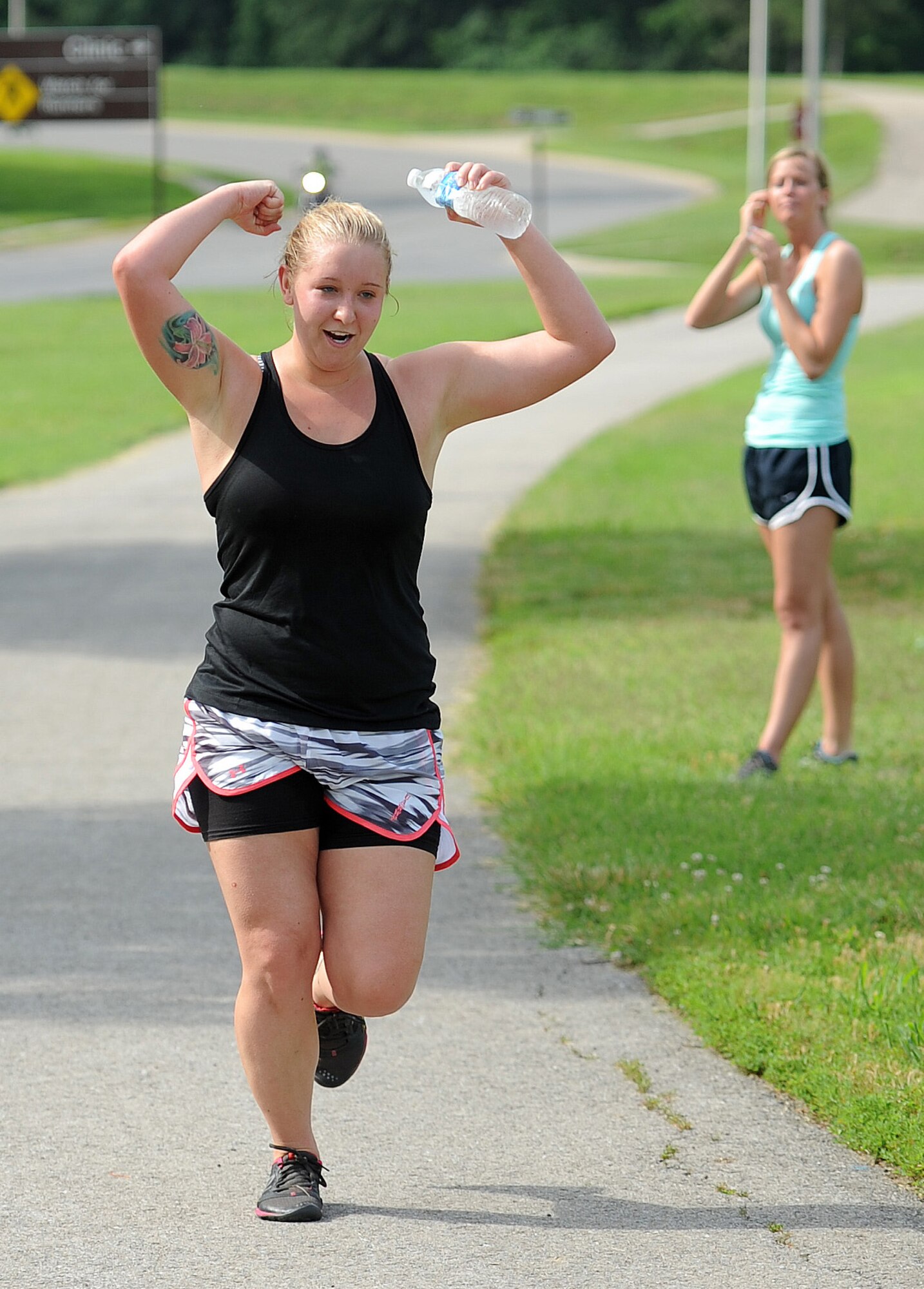 Senior Airman Andrea Huffstetler, 509th Medical Operations Squadron, celebrates after finishing a triathlon at Whiteman Air Force Base, Mo., June 21, 2013. Huffstetler finished with a time of 1 hour, 25 minutes and 2 seconds. (U.S. Air Force photo by Staff Sgt. Nick Wilson/Released)