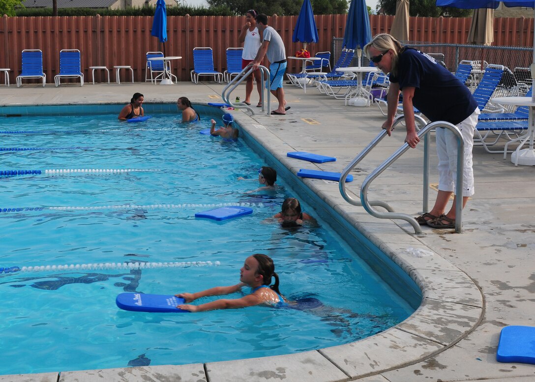 Jeanene Graves, 9th Force Support Squadron youth sports and fitness director, coaches the Beale Barracudas swim team during practice at the base pool at Beale Air Force Base, Calif., July 2, 2013. Graves instructs newer Barracuda team members to practice proper kicking techniques. (U.S. Air Force photo by Senior Airman Allen Pollard/Released)