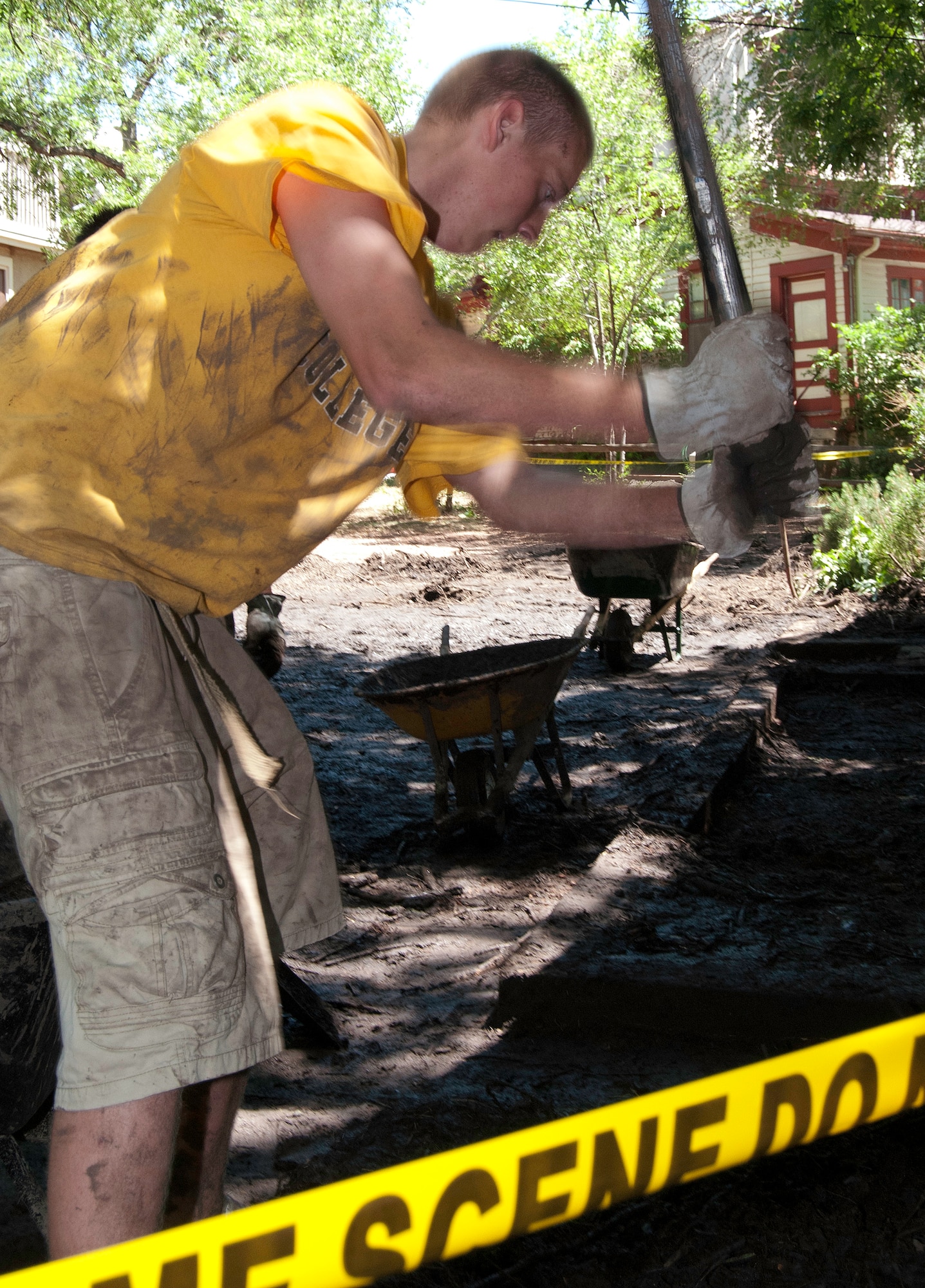 Skyler Cabell clears debris from the front steps of a house in Manitou Springs, Colo., July 2, 2013. Significant rainfall in areas affected by the 2012 Waldo Canyon Fire triggered a flash flood that damaged several homes along the Black Canyon watershed. Cabell, an employee for a local landscaping company, volunteered to help with cleanup efforts. (U.S. Air Force photo/Don Branum)