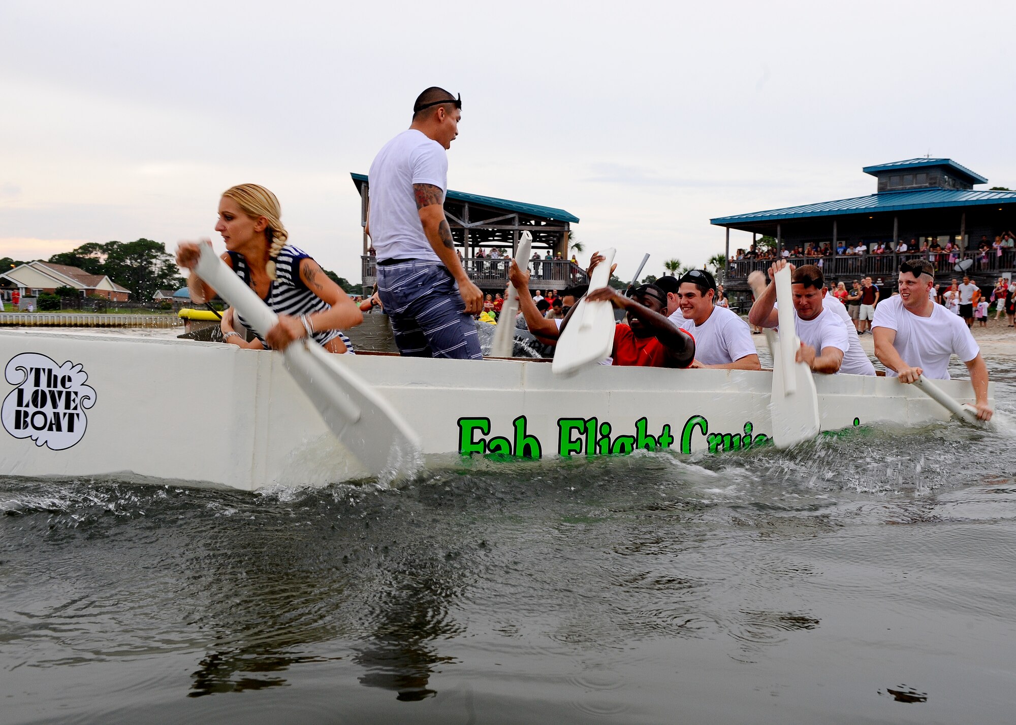 Members of the 1st Special Operation Equipment Maintenance Squadron, defending champions row their boat The Fab Love Boat to a second place finish during the 25th annual cardboard boat regatta at the Soundside Marina on Hurlburt Field Fla., June 28, 2013. The 1st SOEMS valiantly defended their title but came short and accepted defeat to the 823rd RED HORSE. (U.S. Air Force photo by Airman 1st Class Jeffrey Parkinson)
