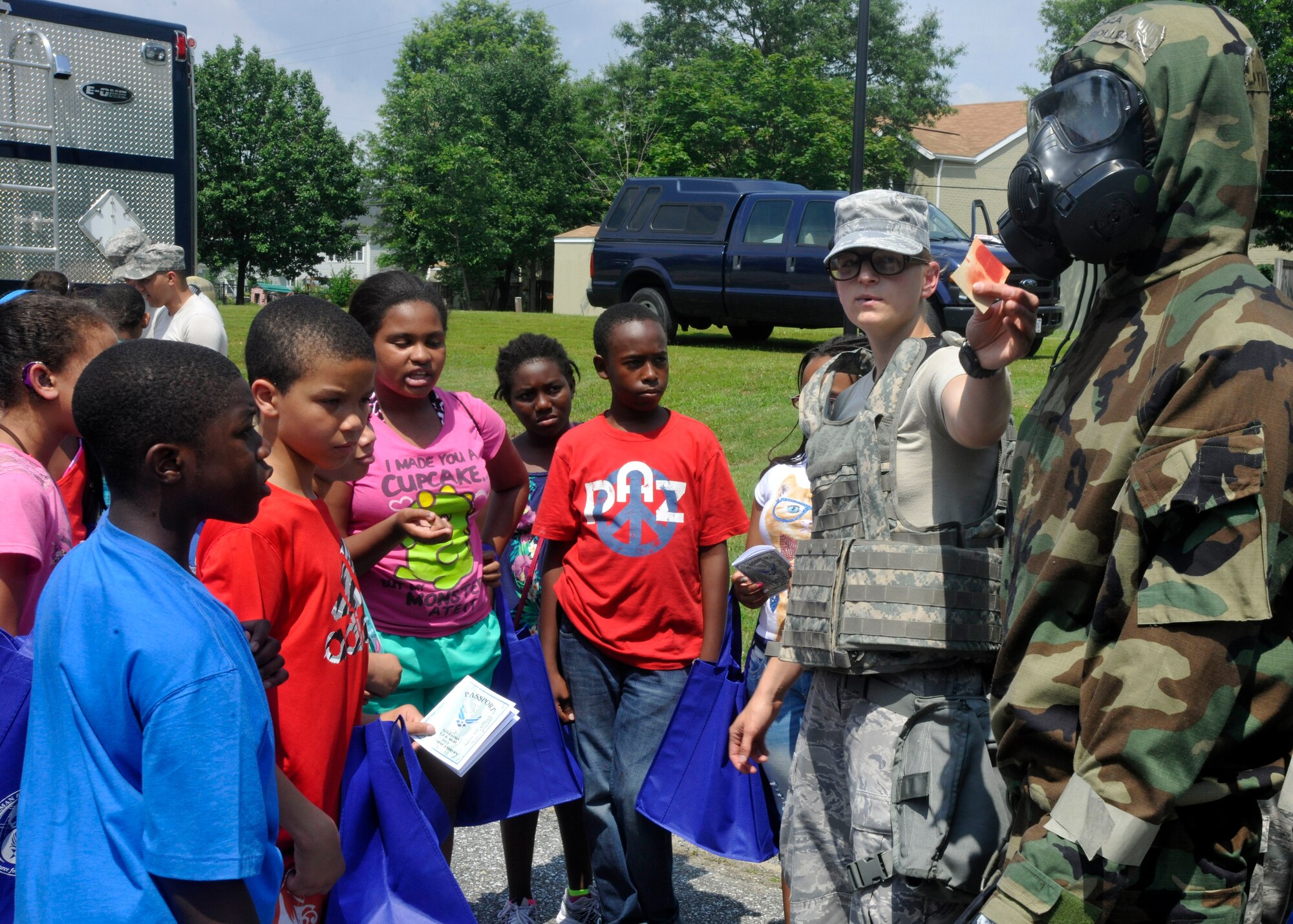 Airman 1st Class Dana Vahey, 11th Civil Engineer Squadron emergency management technician, discusses the reactive properties of M9 Chemical Agent Detection Paper during Operation KID Mode June 28, 2013 at Joint Base Andrews, Md. Operation KID Mode is an annual event on Andrews, held to help children of service members cope and understand their parents' deployment process. (U.S. Air Force photo/Senior Airman Lindsey A. Porter)