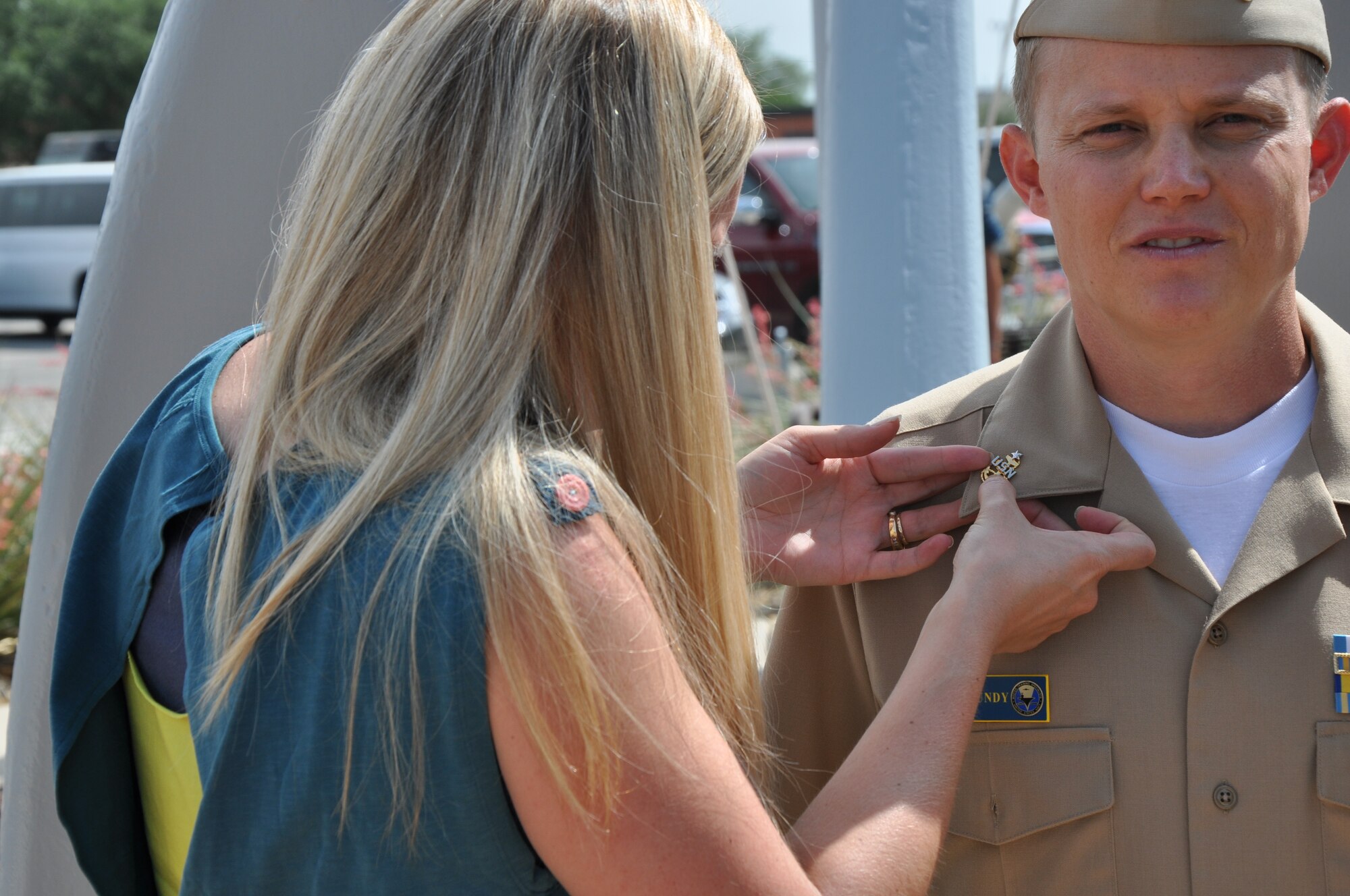 GOODFELLOW AIR FORCE BASE, Texas – Tiffany Roundy, Navy Senior Chief Joshua Roundy’s wife, pins her husband’s senior chief insignia onto his uniform at the Navy Center for Information Dominance Detachment, June 28. From all the services at Goodfellow, Joshua Roundy was the only senior NCO to be selected for E-8 during 2013. (U.S. Air Force photo/ Airman 1st Class Joshua Edwards)