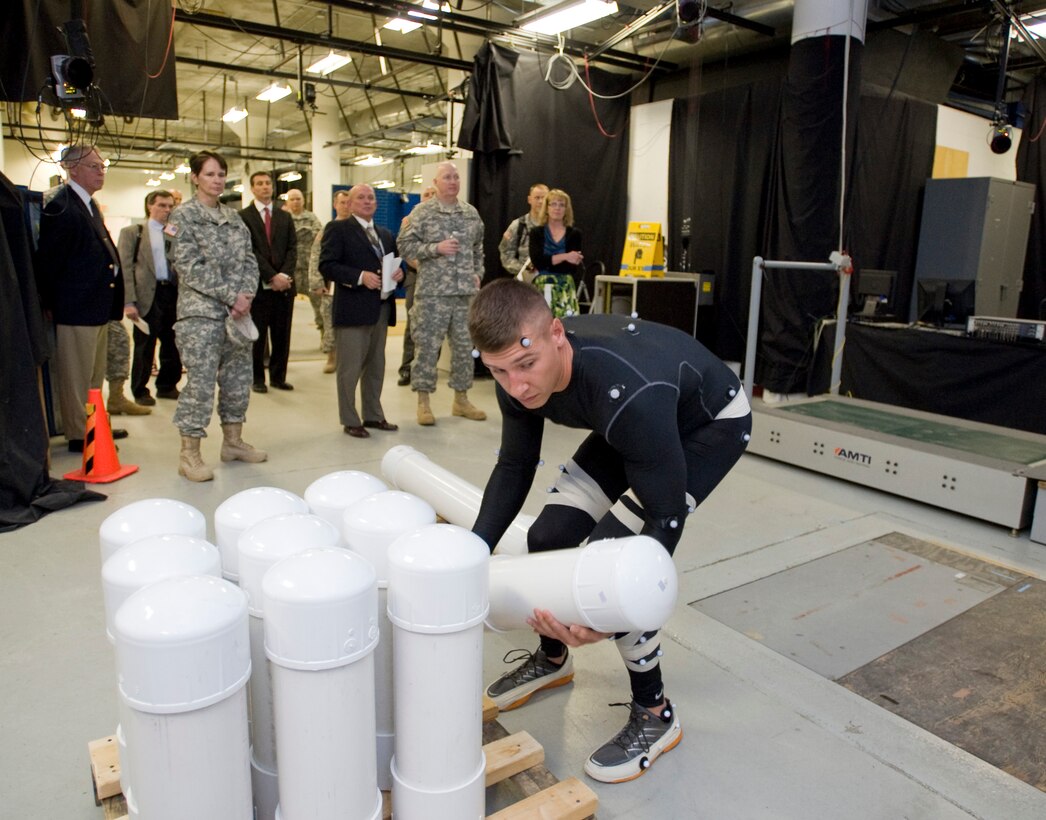 Sgt. Shaun M. Morand, a noncommissioned officer with U.S. Army Medical Command's U.S. Army Research Institute for Environmental Medicine's Military Performance Division, performs a simulated artillery load at USARIEM's Center for Biomechanics Research in Natick, Mass., May 6, 2013, as Gen. Robert W. Cone, commanding general of U.S. Army Training and Doctrine Command, observes with members of USARIEM and TRADOC. The task simulation is part of a larger effort led by TRADOC to review the physical standards for all Soldiers for every military occupational specialty, or MOS, throughout the Army. (U.S. Army photo by David Kamm/Released)