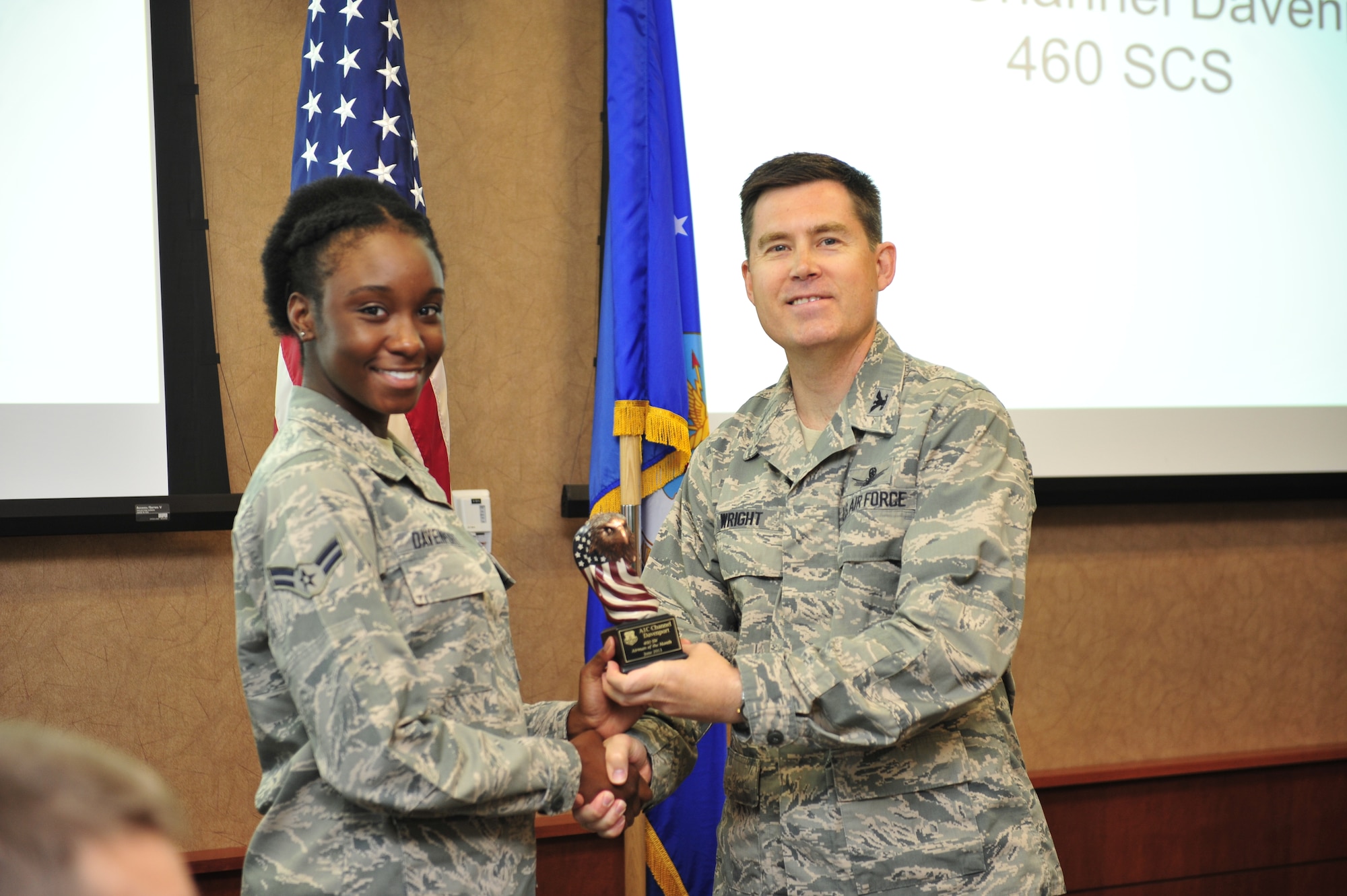 Airmen 1st Class Channel Davenport, 460th Space Communications Squadron, accepts Airmen of the Month Award from Col. Dan Wright, 460th Space Wing commander, July 2, 2013, at Buckley Air Force Base, Colo. Davenport distinguished herself by tracking and accounting for 89 mission critical items valued more than $200,000. She also serves on the Mile High Honor Guard and rendered two military funerals, affording dignity and respect to veterans. (U.S. Air Force photo by Airman 1st Class Darryl Bolden Jr./Released)